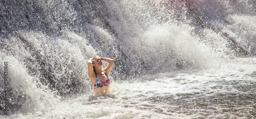 Beautiful lady staying by the waterfall