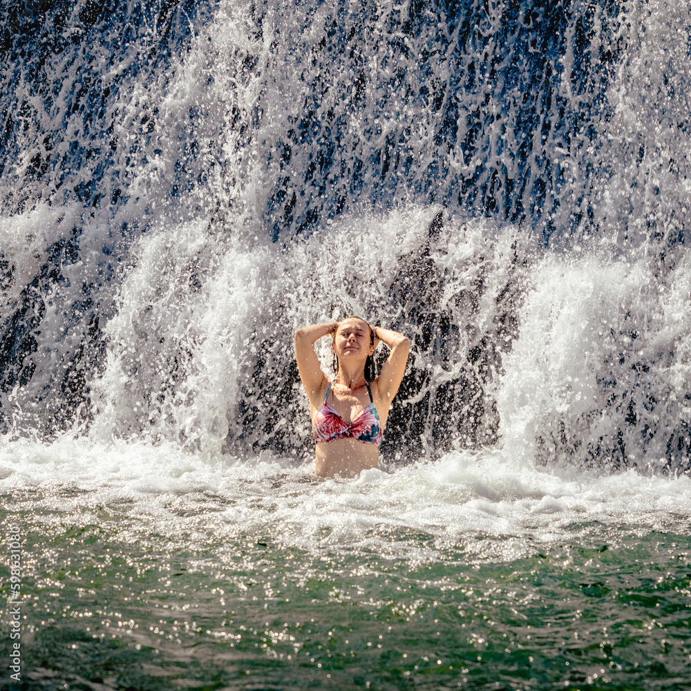 Beautiful lady staying by the waterfall