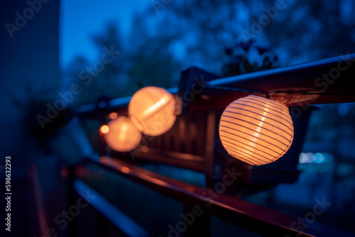 Obraz na plátne A lighted garland with solar lamps hung on the balustrade of the balcony