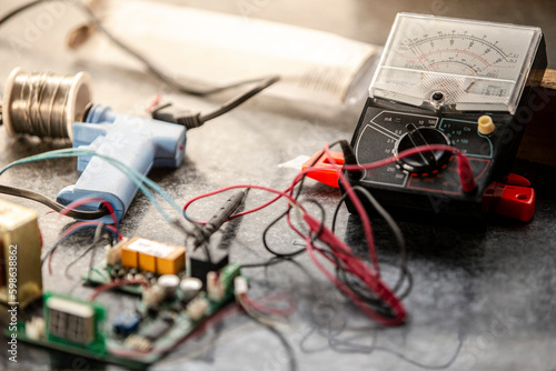 Old multimeter and electronic components on the table. Toned.
