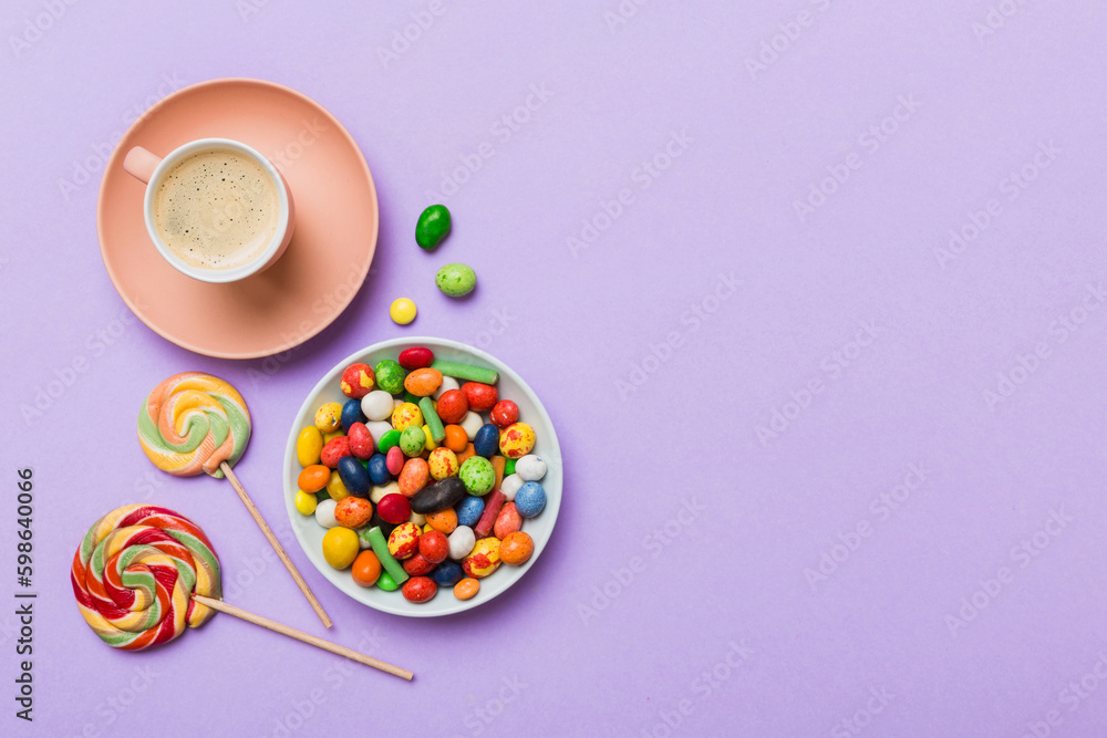 Coffee cup with chocolates and colored candy. Top view on table background with copy space