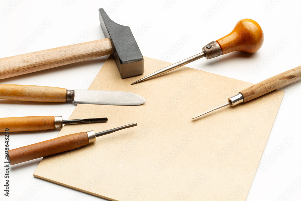 Herramientas de trabajo, gubias, martillo, cuchillo, punzón y madera. Vista superior y de cerca. Copy space