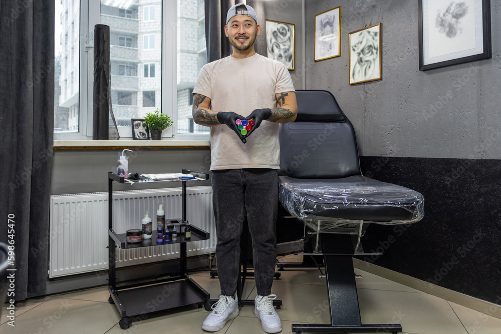 Man in gloves holding tattoo ink Man in gloves holding tattoo ink