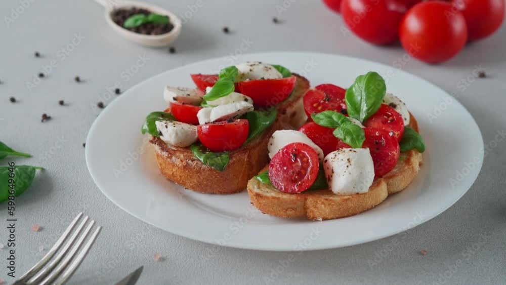 Close-up of Bruschetta with tomatoes, mozzarella and basil leaves on light background. Crostino Caprese Close-up of Bruschetta with tomatoes, mozzarella and basil leaves on light background. Crostino Caprese