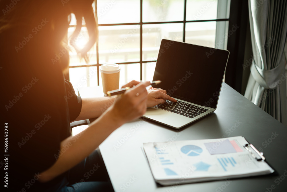 Fototapeta premium Business women are looking at the company's financial documents to analyze problems and find solutions before bringing the information to a meeting with a partner.