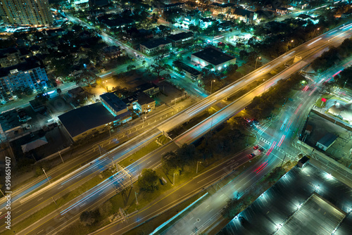 Aerial view of american freeway intersection at night with fast driving cars and trucks in Tampa, Florida. View from above of USA transportation infrastructure