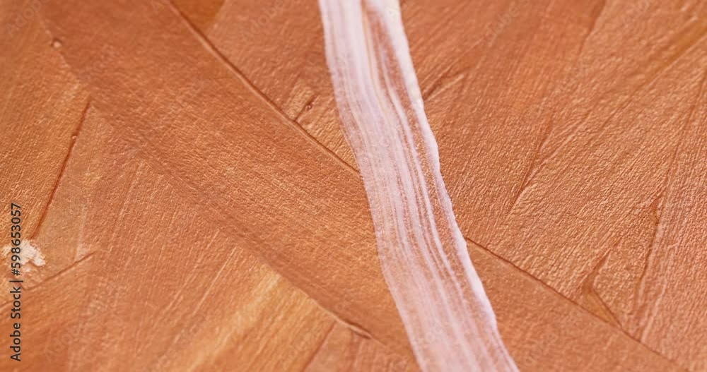 drawing lines with gold paint on canvas with an artistic brush, using