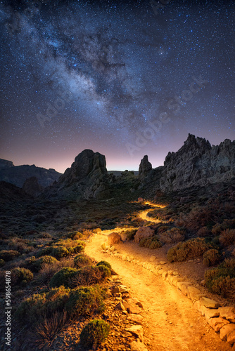 Night time image of the Roque de Garcia with illuminated hiking path and Milky way galactic center stars on Tenerife, Spain