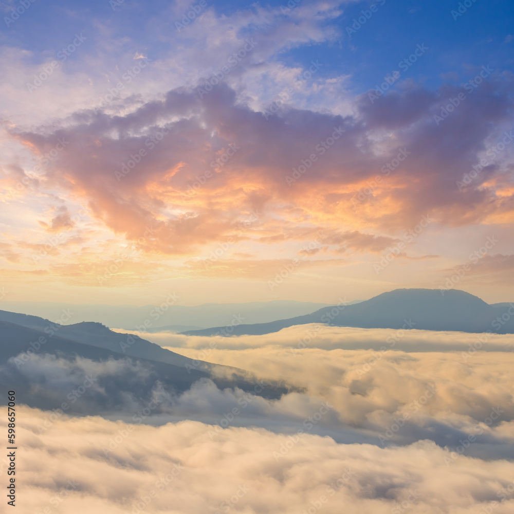 mountain chain in dense clouds at the sunset, evening mountain travel scene