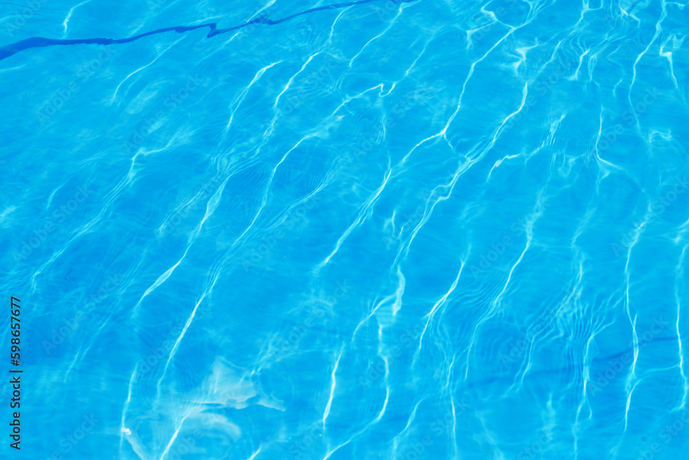 Abstract stylish texture of blue waves and highlights. Clean clear water of the pool. A stylish concept of relaxation in hotels and spas. Relaxing in the pool and relaxing for the family