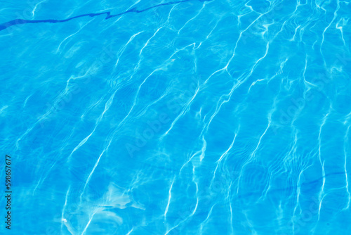 Abstract stylish texture of blue waves and highlights. Clean clear water of the pool. A stylish concept of relaxation in hotels and spas. Relaxing in the pool and relaxing for the family