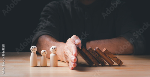 Risk Management Concept. Businessman hand stopping wooden domino business crisis effect, protection, falling to family. Concept of Risk Management, Assessment, Insurance, Security, Financial, Economic