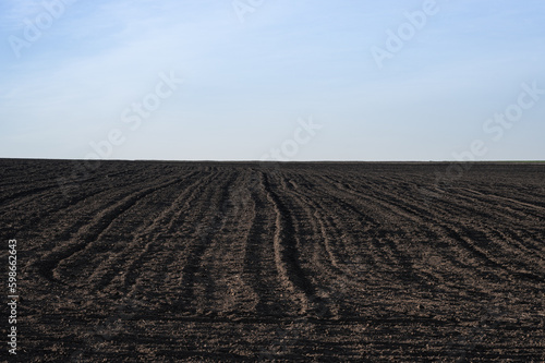 A field of black plowed land and the horizon line