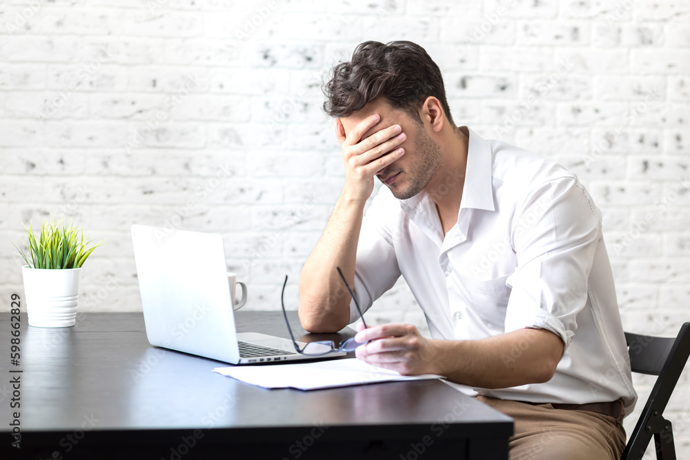 Stressed man working on laptop at home. Distance work concept Stressed man working on laptop at home. Distance work concept
