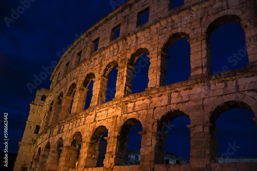 Beautiful Pula Arena at Night. European Historical Landmark with Evening Sky. Roman Amphitheater with Arch in Istria.