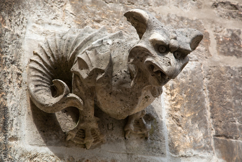 Kleine Figur eines Drachen oder Monsters aus Stein an der Wand einer Kirche photo