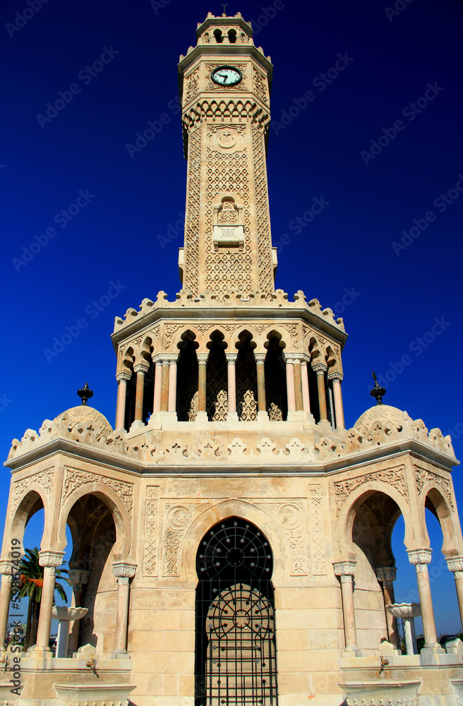 Photo with the view from below of the Konak Clock Tower againt the clear blue sky in the historic center of Izmir, Turkey
