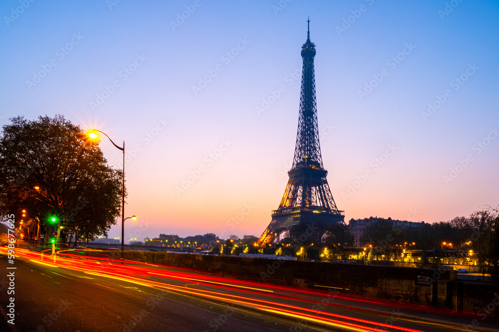 Silhouette of the Eiffel Tower at dawn with blurred red lights of traffic. Paris, France