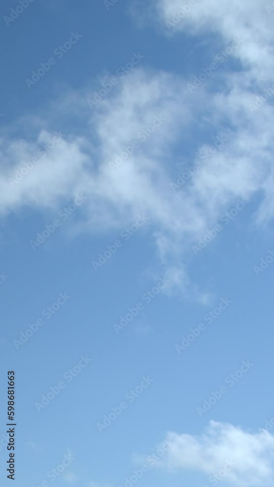 Clear blue sky with fast-moving cumulus clouds. Vertical video. Clear blue sky with fast-moving cumulus clouds. Vertical video.