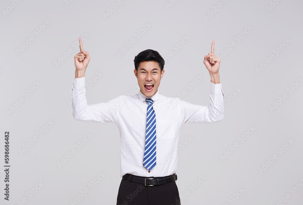 Happy smiling Asian businessman pointing finger to empty copy space isolated on white studio background. Happy smiling Asian businessman pointing finger to empty copy space isolated on white studio background.