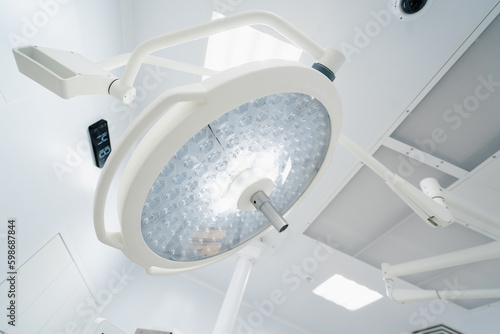 Big round modern lamps on the surgery room ceiling Advanced illumination equipment for surgeries in present day clinics photo