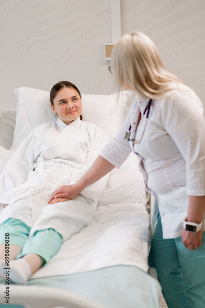 Obraz premium A doctor holds a patient's hands as a sign of care and support after revealing a diagnosis in a hospital room