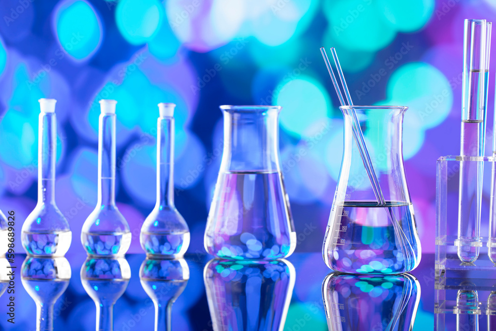 Laboratory investigations. Glass tubes and beakers on blue bokeh background. Laboratory investigations. Glass tubes and beakers on blue bokeh background.