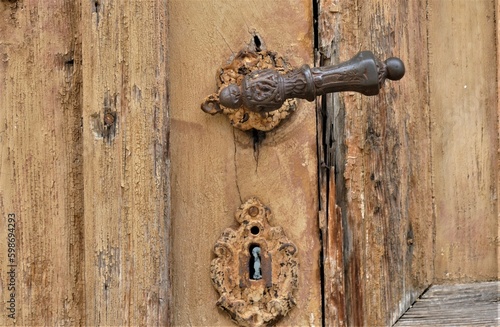 Old wooden door with metal knob and ornaments