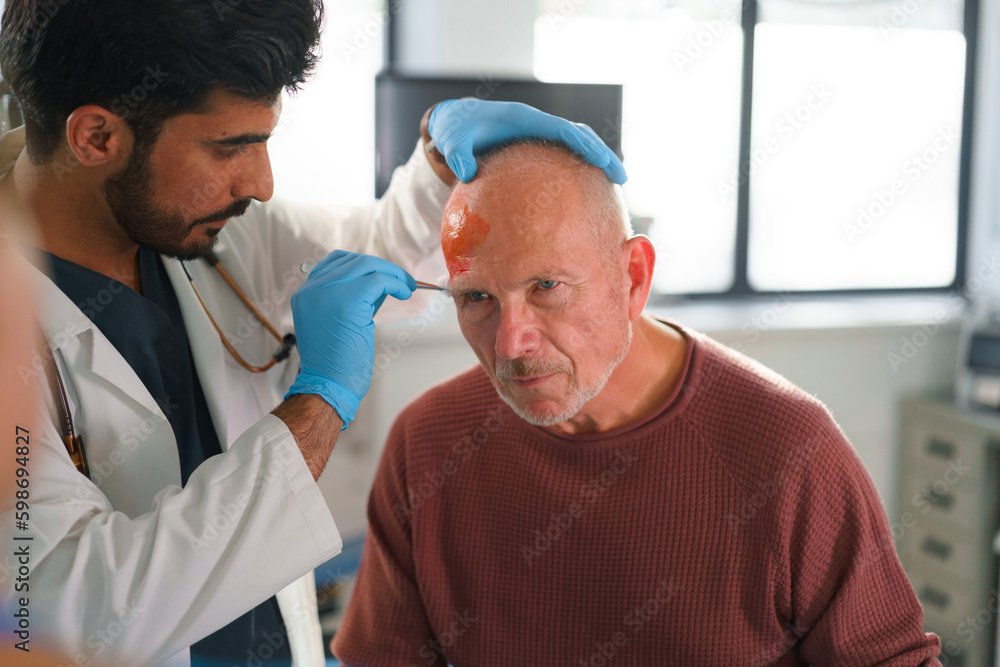 Obraz premium Close-up of doctor treating injury of senior man.