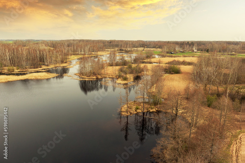 Fototapeta Naklejka Na Ścianę i Meble -  A river with trees and a cloudy sky