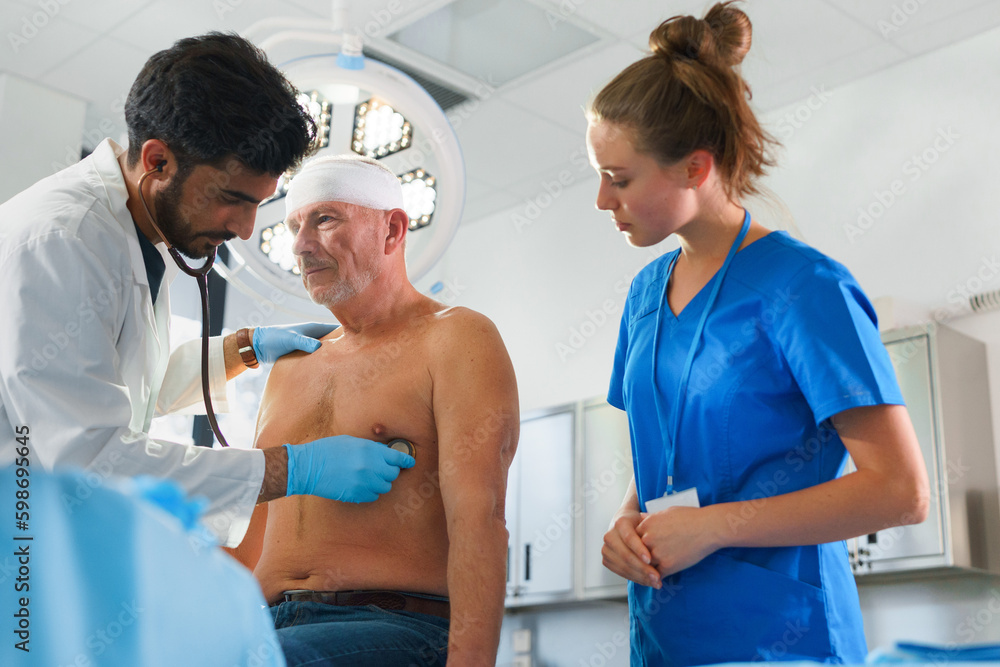 Obraz premium Close-up of doctor and nurse treating injury of senior man.