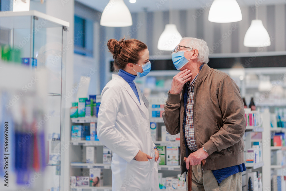 Obraz premium Young pharmacist helping senior man to choos medication.