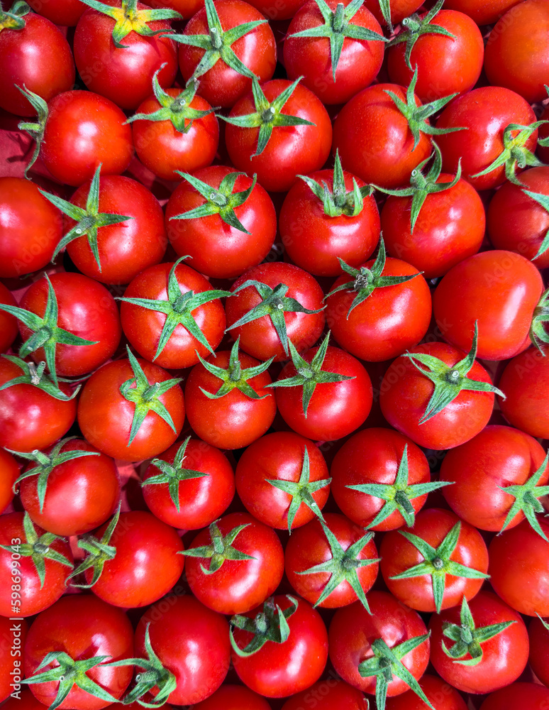 Pattern of red small cherry tomatoes. Top view of fresh organic vegetables, close-up. Natural products grown in the garden. Pattern of red small cherry tomatoes. Top view of fresh organic vegetables, close-up. Natural products grown in the garden.