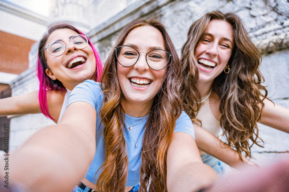 Group of young women friends taking selfie shot with smartphone while smiling -Three happy multiracial girls having looking at camera outdoors at city-Cheerful Friendship and Diversity Concept Group of young women friends taking selfie shot with smartphone while smiling -Three happy multiracial girls having looking at camera outdoors at city-Cheerful Friendship and Diversity Concept
