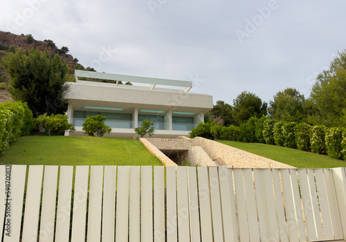 Villa in Los Monasterios Urbanization residential area. Design house and luxury facilities. Fence at a suburb house. Construction of modern house near coastline. Villa under construction in mountains
