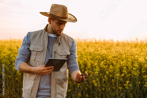 A man is holding soil from the field and looking to determine its quality.