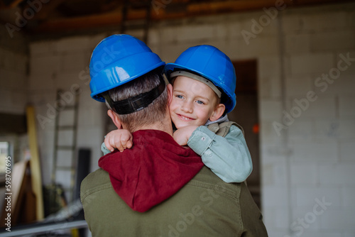 Father and his little son cuddling in their unfinished house.