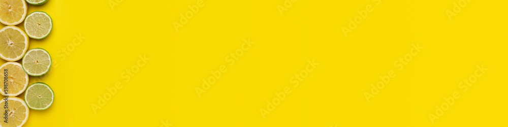Fresh, Fruity and juicy fruit concept with free text space, web banner. Flat layout with fresh cut lemons and limes fruits on the left side of the picture on a yellow background Fresh, Fruity and juicy fruit concept with free text space, web banner. Flat layout with fresh cut lemons and limes fruits on the left side of the picture on a yellow background