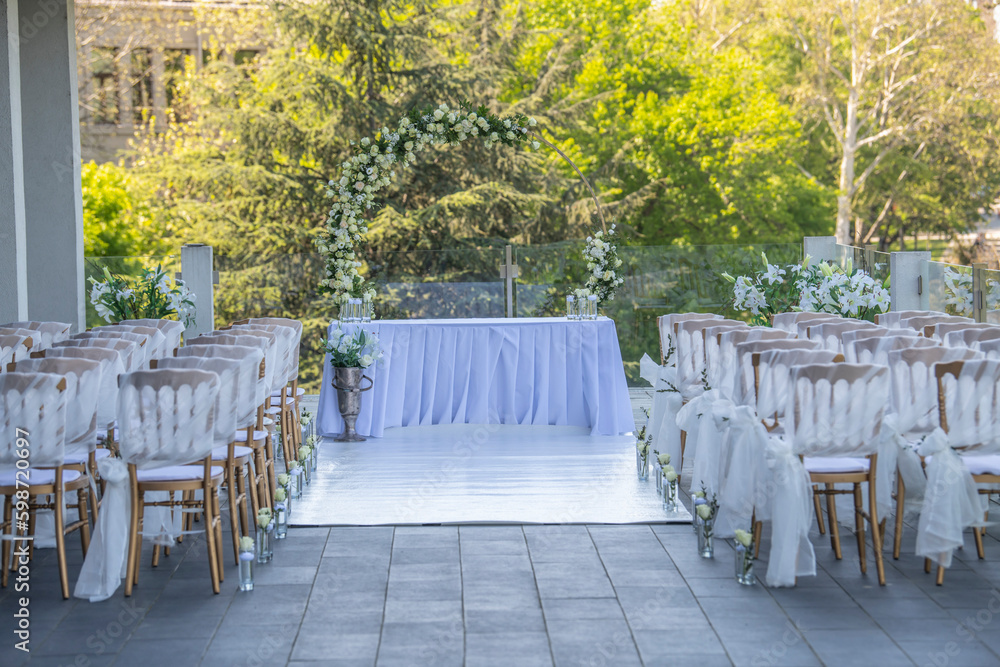 A beautiful wedding ceremony with flowers on the terrace at sunset