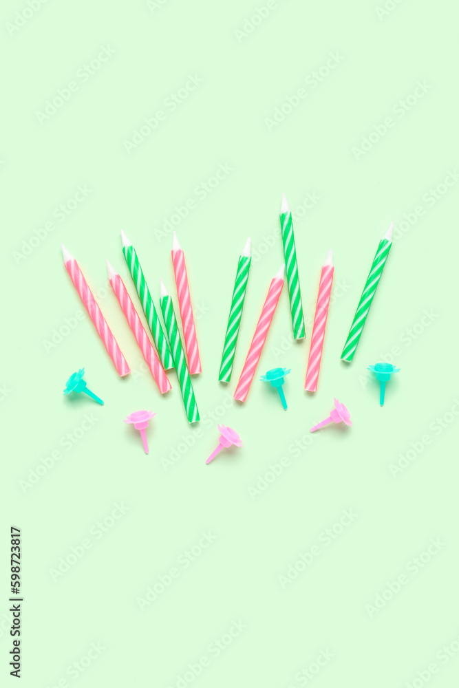 Colorful birthday candles on green background