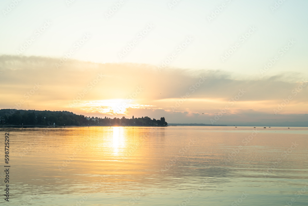 Beautiful sunrise view from Imperia statue at harbor entrance on lake Constance in early morning hours. Steamer harbor, Constance, Baden-Württemberg, Germany, Europe. Beautiful sunrise view from Imperia statue at harbor entrance on lake Constance in early morning hours. Steamer harbor, Constance, Baden-Württemberg, Germany, Europe.