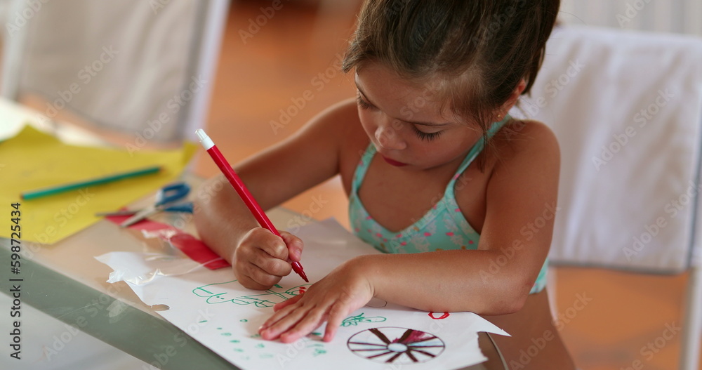 Child girl drawing with red color pen on paper at home. Focused creative kid Child girl drawing with red color pen on paper at home. Focused creative kid