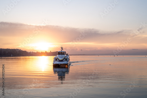 Beautiful sunrise view from Imperia statue at harbor entrance with catamaran ferry on lake Constance in early morning hours. Steamer harbor, Constance, Baden-Württemberg, Germany, Europe.