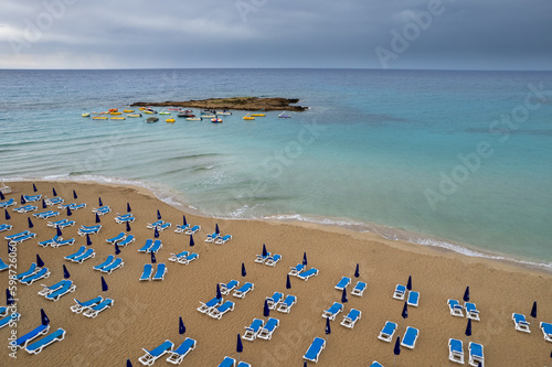 Drone aerial of beach chairs in a  tropical sandy beach. Summer holidays in the sea. Protaras Cyprus Europe © Michalis Palis