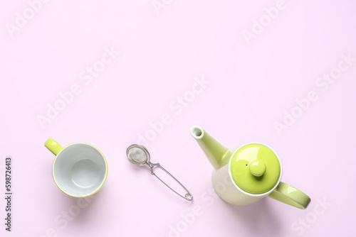 Teapot, mug and infuser on lilac background