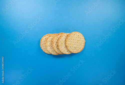 overlapping line of five round fresh biscuits isolated on a dark blue background