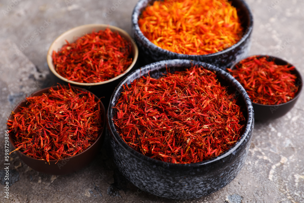 Bowls with pile of saffron on grey grunge background Bowls with pile of saffron on grey grunge background