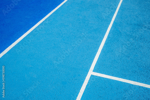 Sport field court background. Light blue rubberized and granulated ground surface with white lines. Top view