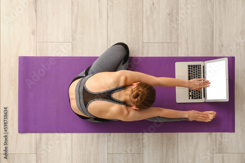 Woman stretching on yoga ma...