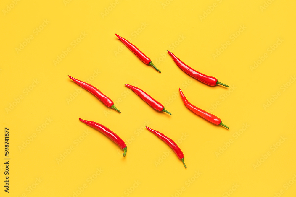 Fresh hot chili peppers on yellow background Fresh hot chili peppers on yellow background